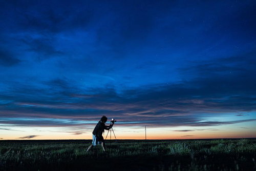 夜明け前のモンゴルの草原で撮影するカメラマン