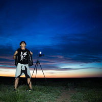 朝焼けのモンゴル草原で撮影するカメラマンの写真