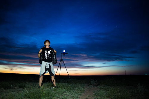 朝焼けのモンゴル草原で撮影するカメラマン