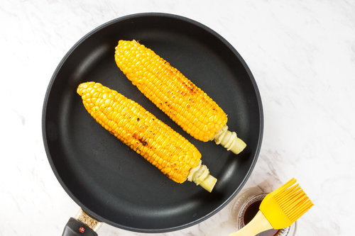 黒いフライパンでとうもろこしに焦げ目をつける