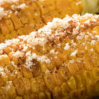 こんがり焼いたとうもろこしに、パルメザンチーズと黒胡椒をたっぷりの写真