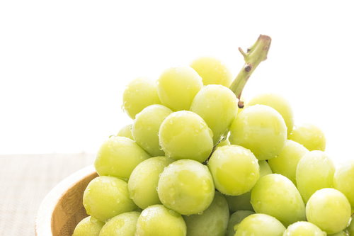 採れたての黄緑色シャインマスカット、木製ボウルに盛られた新鮮なぶどう