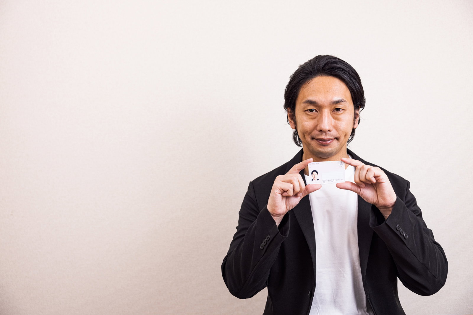 マイナンバーカードを提示する男性［モデル：大川竜弥］