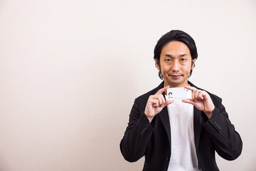 自分の顔写真が入ったマイナンバーを見せる男性