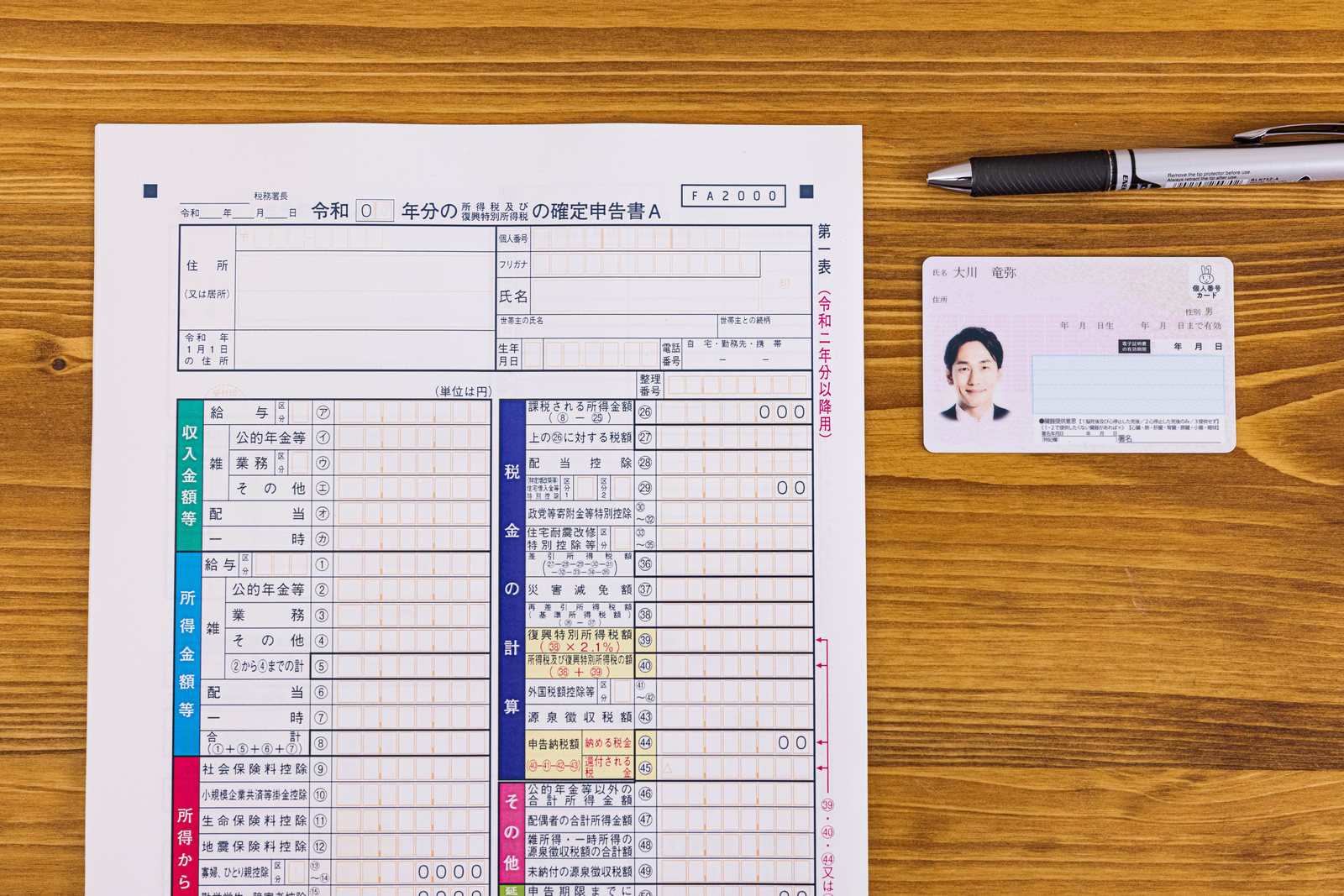 Tax return forms and My Number Card on a wooden table