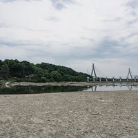 水が減り露わになりひび割れた湖底だった場所から見る普段は見る事の出来ない明治用水旧頭首工の写真