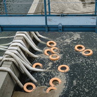 頭首工天端から見える排水ホースと排水ポンプの目印の浮き輪の写真