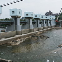 漏水箇所がある明治用水頭首工上流左岸付近の様子と土台付近まで露わになった堤体の写真