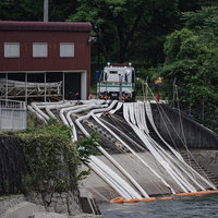 取水の為に川面へと伸びるホースの写真