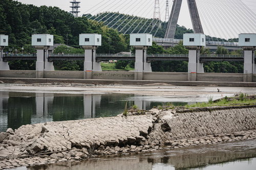 旧頭首工導水堤の石組みの向うに見える土台まで見える明治用水頭首工の堤体と所々のぞく湖底部分