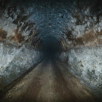 照明がない真っ暗なコンクリートトンネルの奥行きのある深い通路の写真