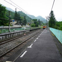 緑の山々に囲まれた旧川原湯温泉駅ホームとJR吾妻線の写真