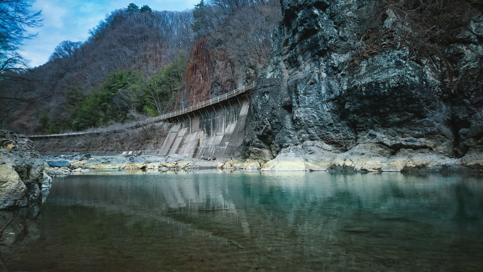 吾妻川の水面に映る川原湯岩脈（臥龍岩）と周囲の自然風景