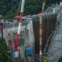 群馬県長野原町の八ッ場ダム建設現場で稼働する赤いクレーンの写真