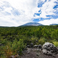 浅間山を望む建設中のダムと山の景観の写真