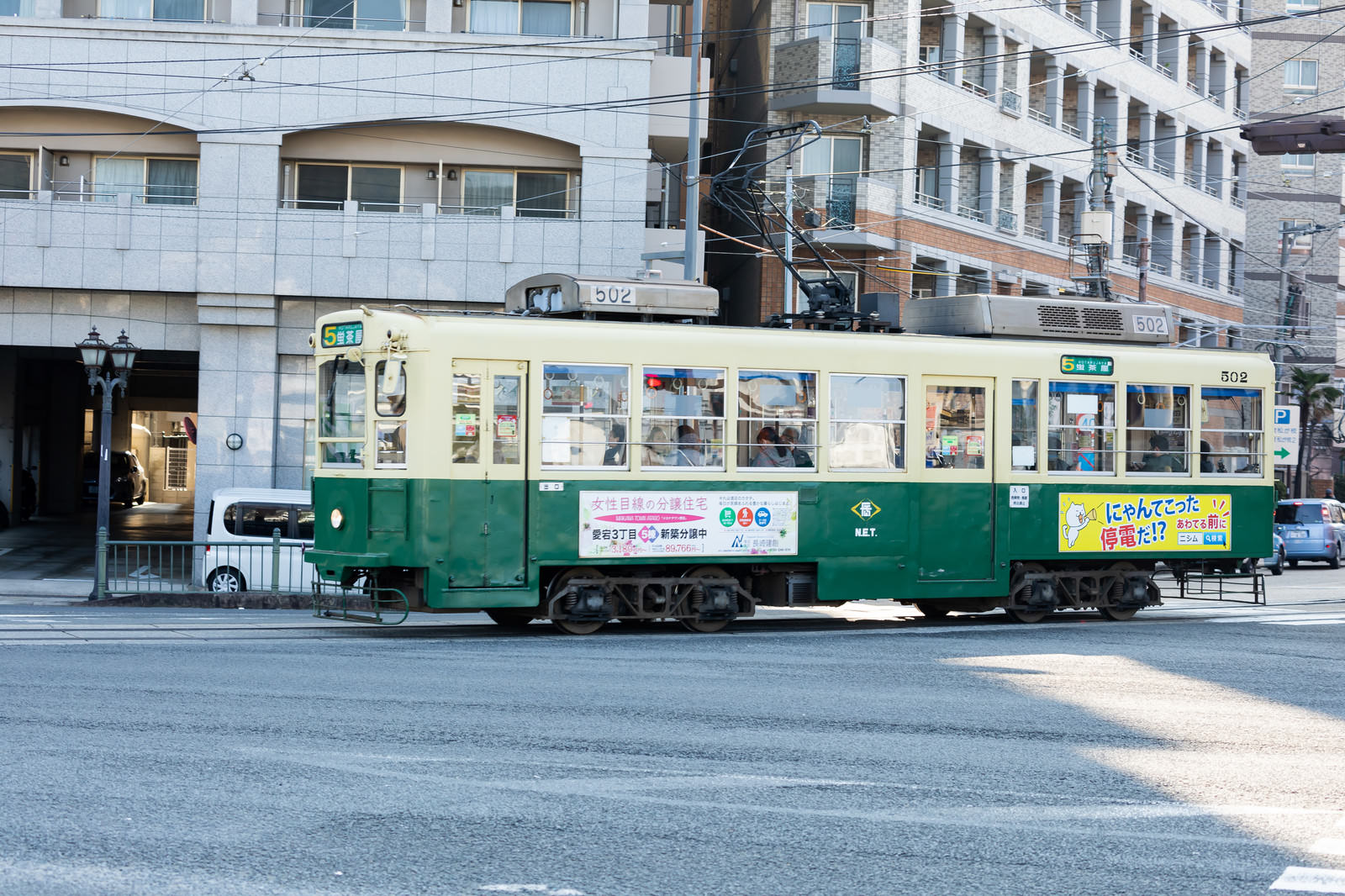 長崎の市街地を走る緑色の路面電車（ちんちん電車）