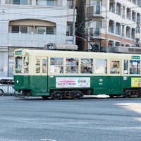 長崎の町を走る緑色の路面電車（ちんちん電車）の写真