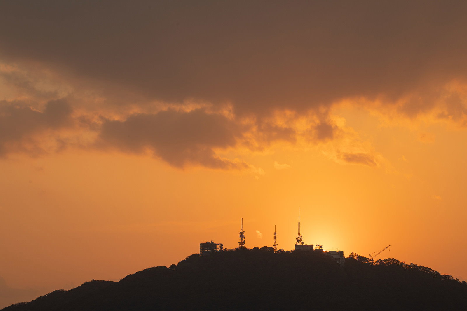 夕焼け空を背景に稲佐山山頂の展望台や鉄塔がシルエットで映る風景