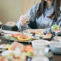 会席料理を食べる浴衣姿の女性の写真