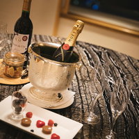 テーブル上に置かれたシャンパンとワインのボトルの写真