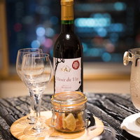 夜景を背景にしたワイングラスとワインボトルの写真