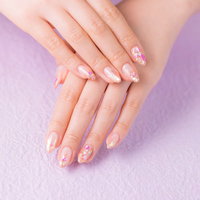 淡いピンク色に染めた可愛いネイルアートの完成度の高い爪の写真