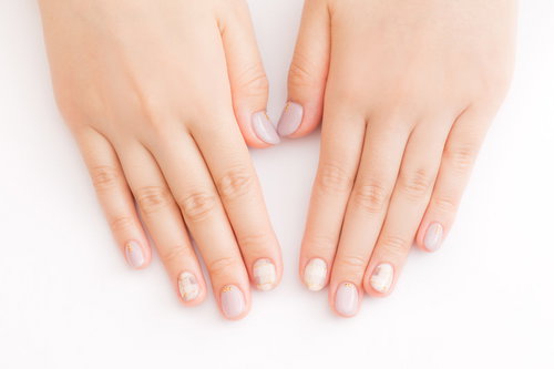 淡いピンクのジェルネイルアートを施した両手