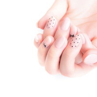 ピンク系ネイルをした女性の手先、上品なドット&ラインデザインの写真