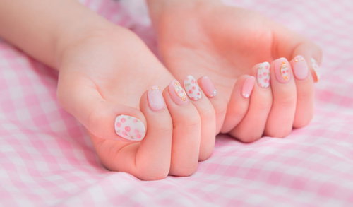 ピンクの背景に映えるさくらんぼのネイルアート