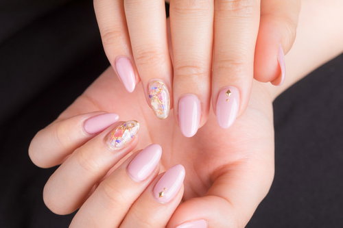 上品なピンクネイルの手先。淡いピンク色のマニキュア