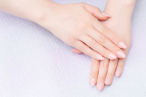 ネイルをした女性の両手（ピンク）