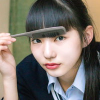 黒髪の前髪にクシを通す女子高生のヘアセットの写真
