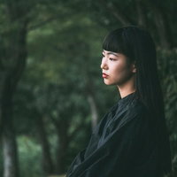 暗い森とロングヘアの女性の写真