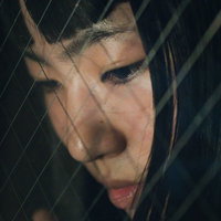 高層階から見下ろす憂鬱女子の横顔と切ない視線の写真