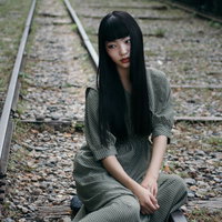 廃線跡に座り込む女性の写真