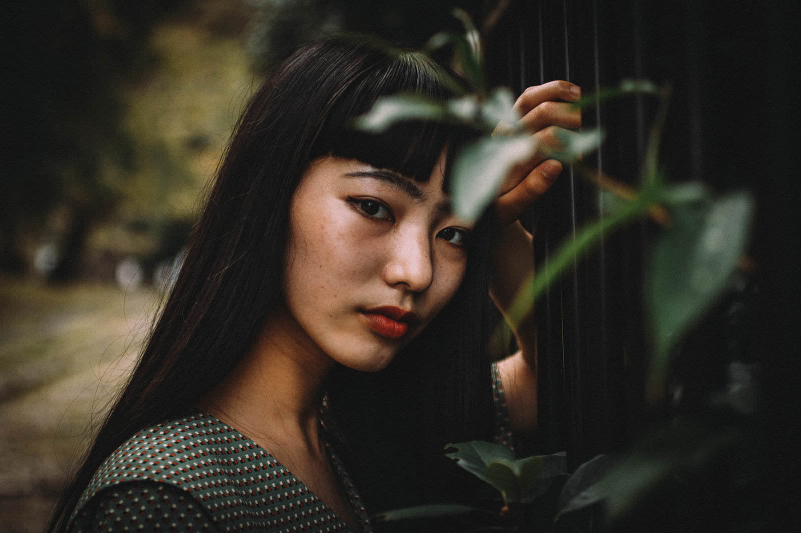 手を頭に当てながら振り向く黒髪の女性のポートレート［モデル：なんこ］