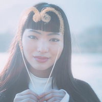 柔らかな光に包まれてハート型をつくる女性のポートレートの写真