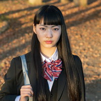 帰宅中の女子高生、秋の夕陽に包まれた学生服姿の写真