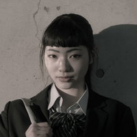 壁に映る学生服姿の女子高生の影のポートレートの写真