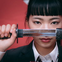 一刀両断を決める制服姿の女子高生が日本刀を抜刀するの写真