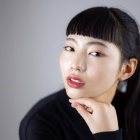 頬杖をついてオン眉で気取るポーズの女性のポートレートの写真