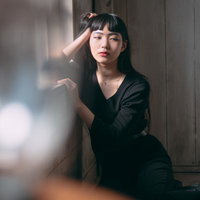 自然光ポトレで自然体の女性、窓辺で思いに耽るの写真