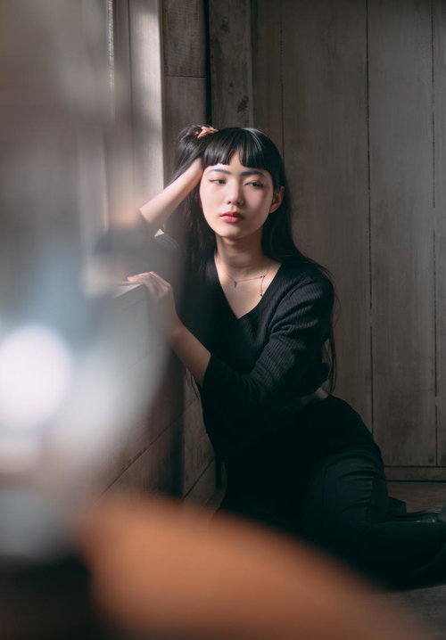 自然光ポトレで自然体の女性、窓辺で思いに耽る