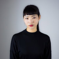 オン眉で真顔のポージングをする女性のポートレートの写真