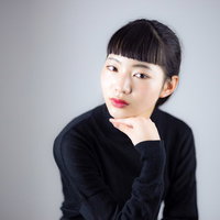 頬杖をついてよそ行きの顔をする黒いセーターの女性の写真