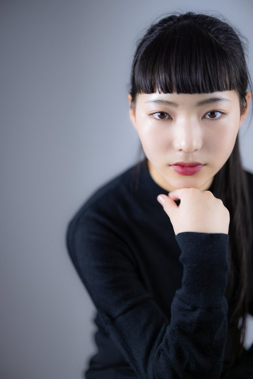 頬杖をついて取り澄ます黒髪の女性のポートレート