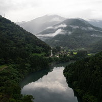 庄川峡の山々に囲まれた菅沼合掌造り集落と茅葺き屋根民家群の写真