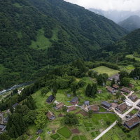 世界遺産の相倉合掌造り集落を流れる庄川の空撮の写真