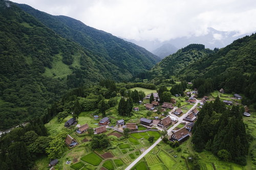 緑の山々に囲まれた相倉集落を一望する空撮
