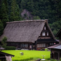 茅葺屋根がある合掌造りの建物と田舎の集落風景の写真